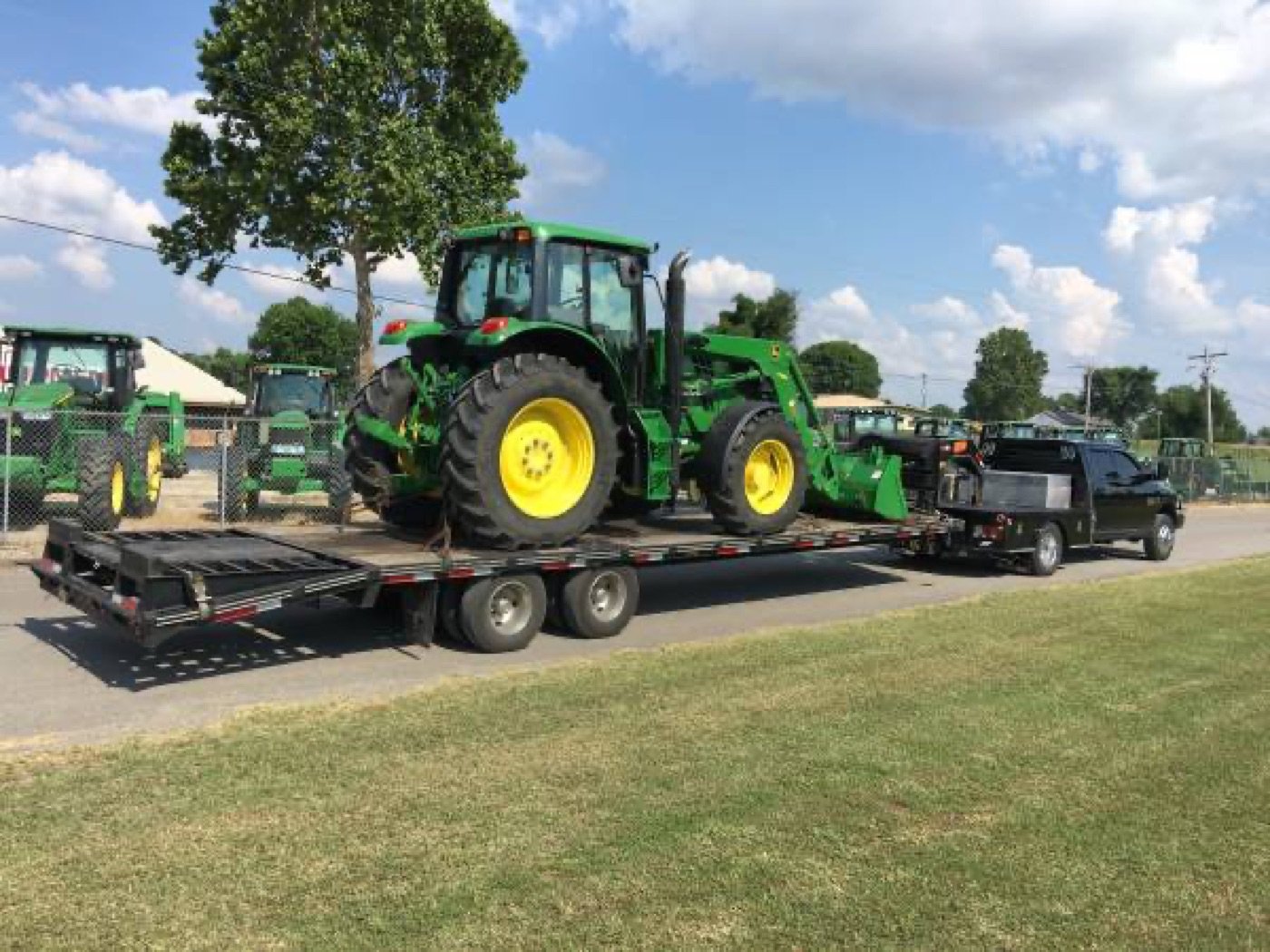John Deere tractor loaded on a trailer for delivery by US Equipment Express