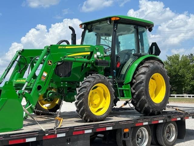A tractor chained down on a flatbed trailer